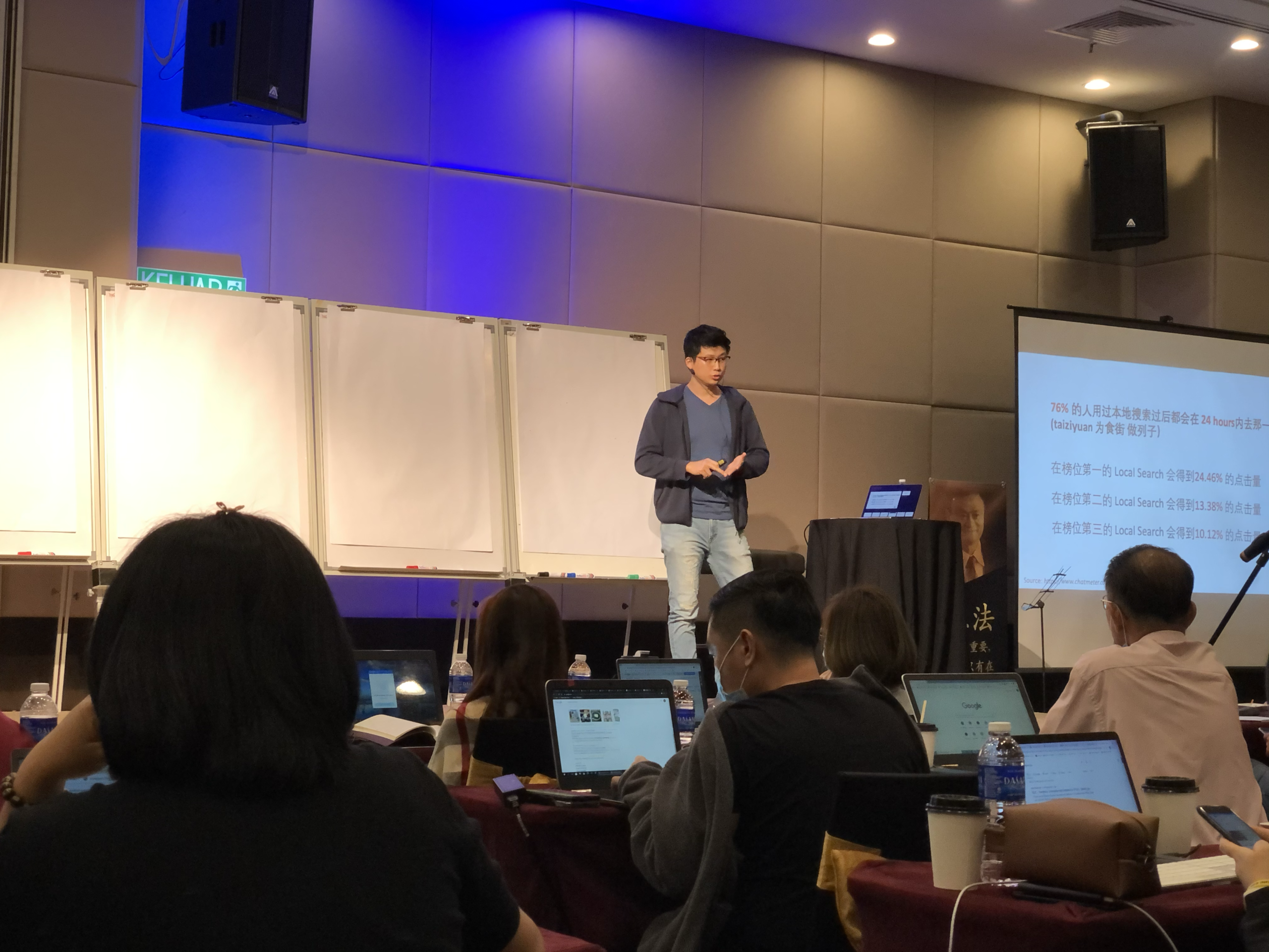 man phuah speaking on stage about local SEO