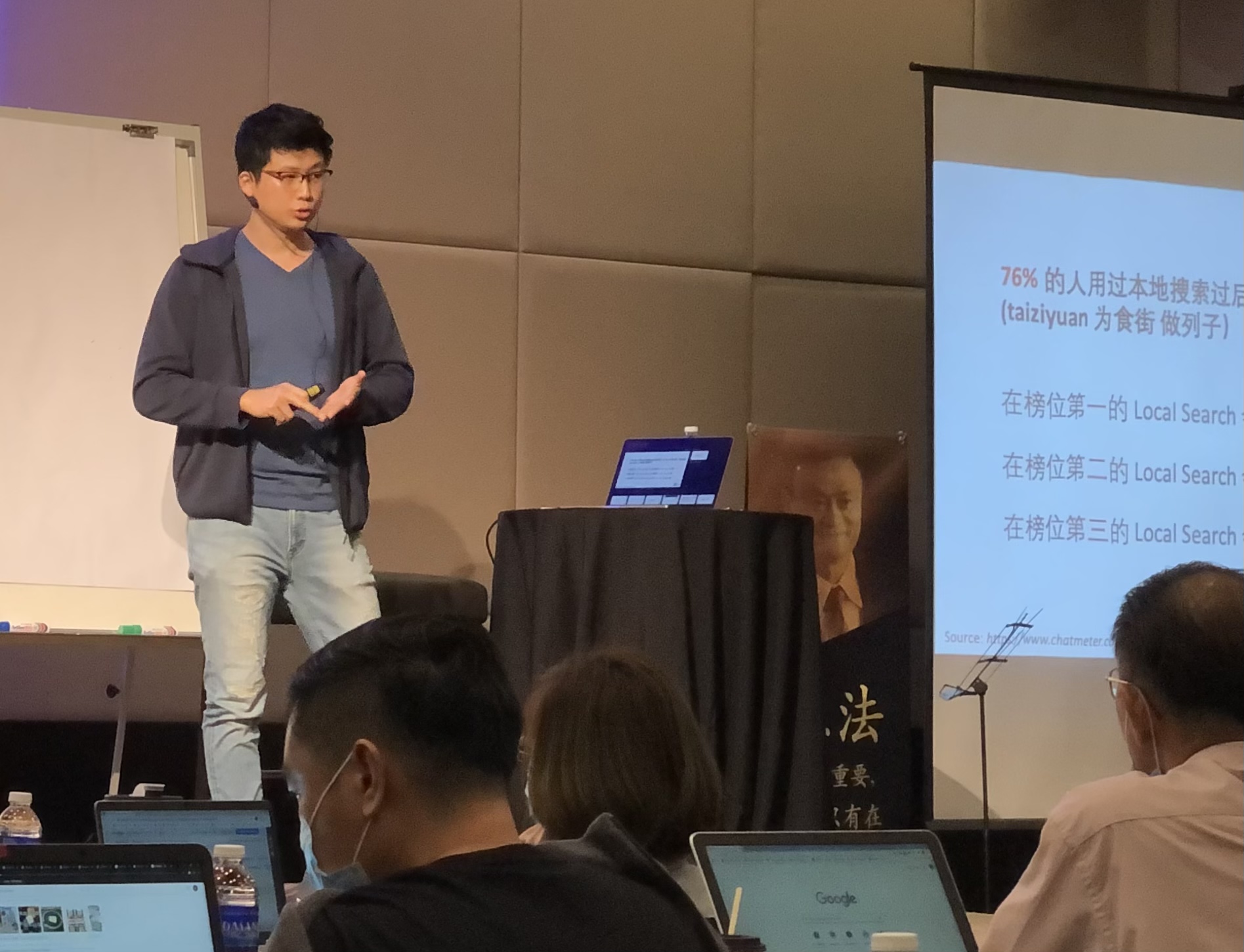 man phuah standing on the stage giving local SEO training to the students